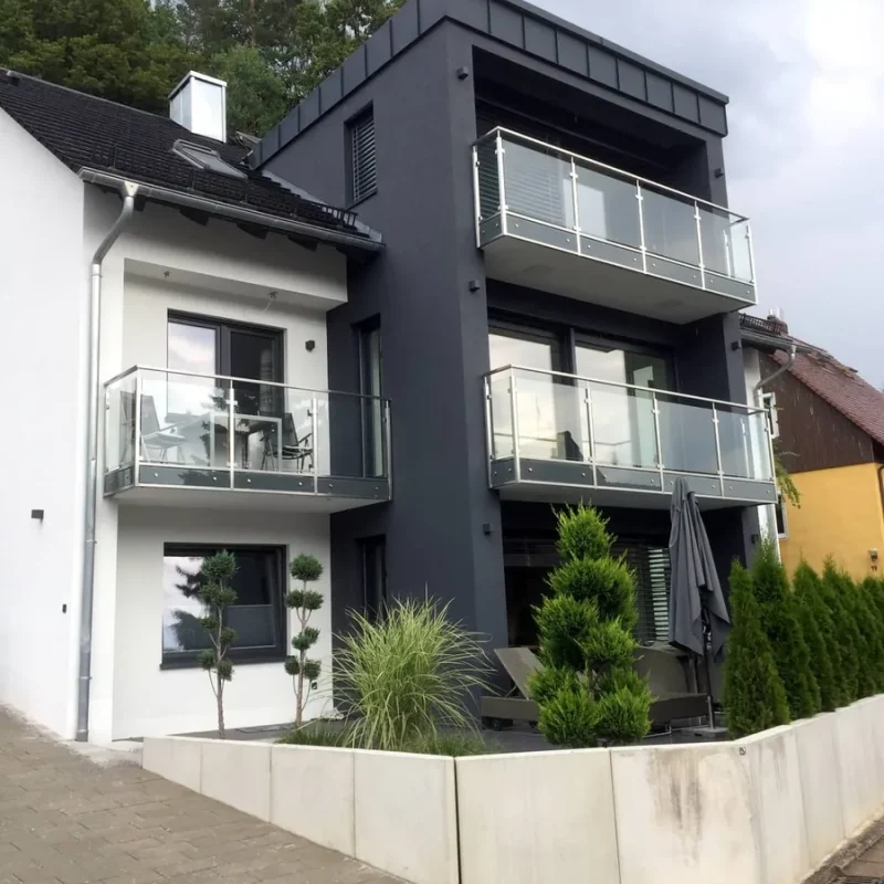 Moderne Schüco Fenster in Anthrazit von NORTA in einem zweistöckigen Gebäude, bieten elegante Optik und hohe Energieeffizienz.