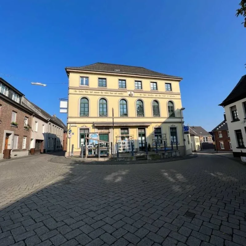 Gelbes Gebäude mit modernen Schüco Fenstern in Bogengestaltung. Energieeffiziente Fensterlösung von NORTA.