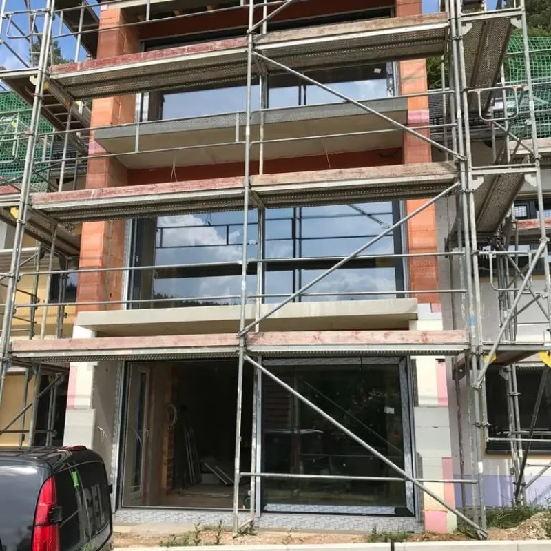 Neubau mit Schüco Fenstern im Gerüst. Hochwertige Fensterlösung von NORTA für moderne Bauvorhaben.