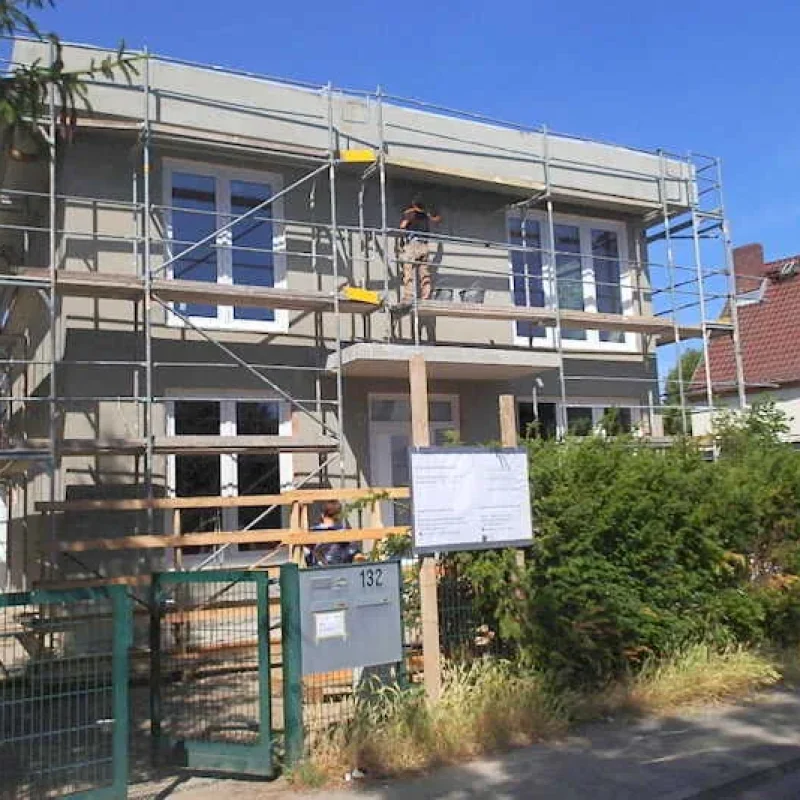 Neubau mit Schüco Fenstern in Berlin, umgeben von Baugerüst. NORTA bietet innovative Fensterlösungen für energieeffizientes Bauen.