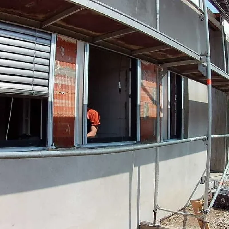 Schüco Fenster mit Raffstoren auf einer Baustelle von NORTA. Installationsfortschritt bei Außenarbeiten.