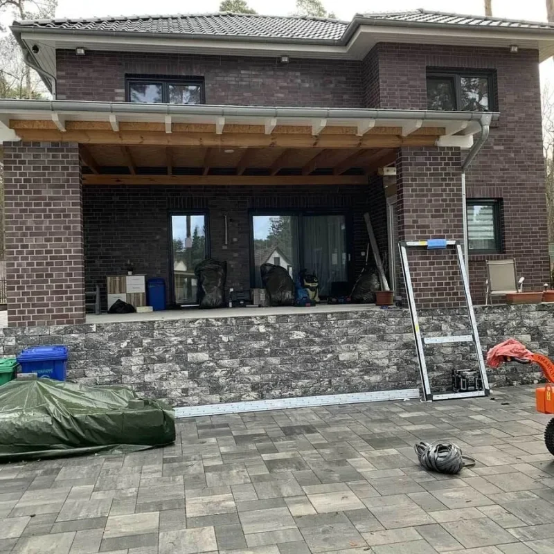 Terrassenüberdachung mit Raffstoren an einem Gebäude. Hochwertige Alu-Konstruktion von NORTA für optimalen Sonnenschutz.