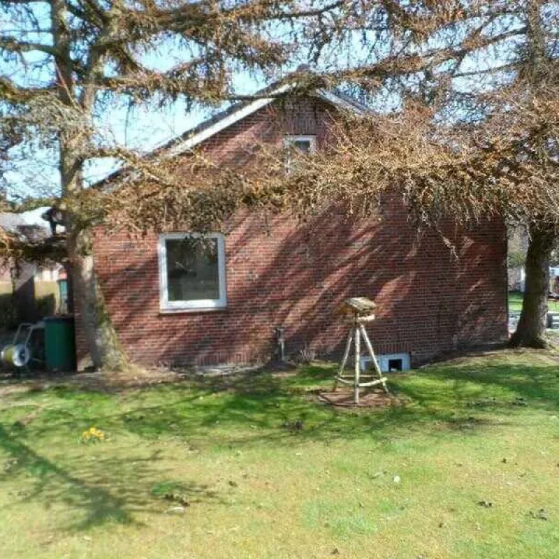 Ziegelfassade eines Hauses im Garten auf Föhr. Robuste Bauweise von NORTA für nachhaltige und ansprechende Optik.