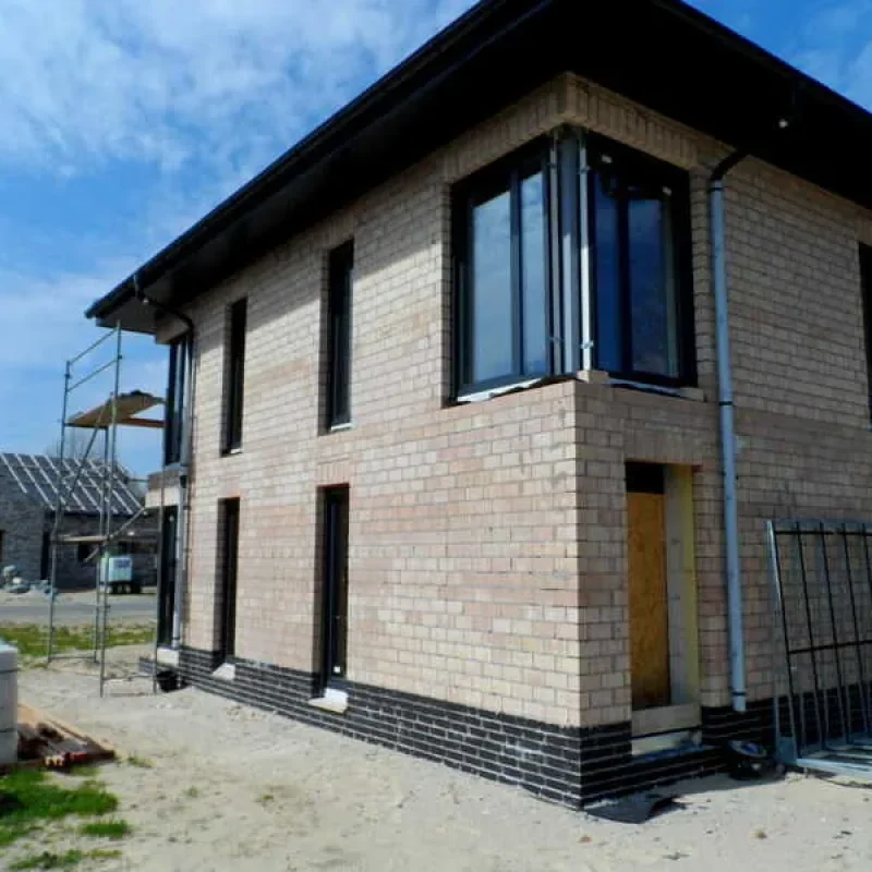 Zweigeschossiges Haus mit Anthrazit-Schüco-Fenstern von NORTA. Modernes Design und hochwertige Bauweise aus Backstein.